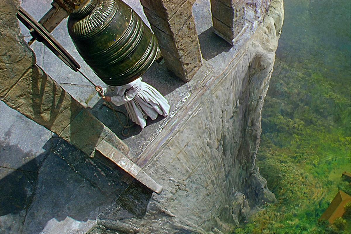 A nun rings a bell perched high on a cliff top in a scene from BLACK NARCISSUS