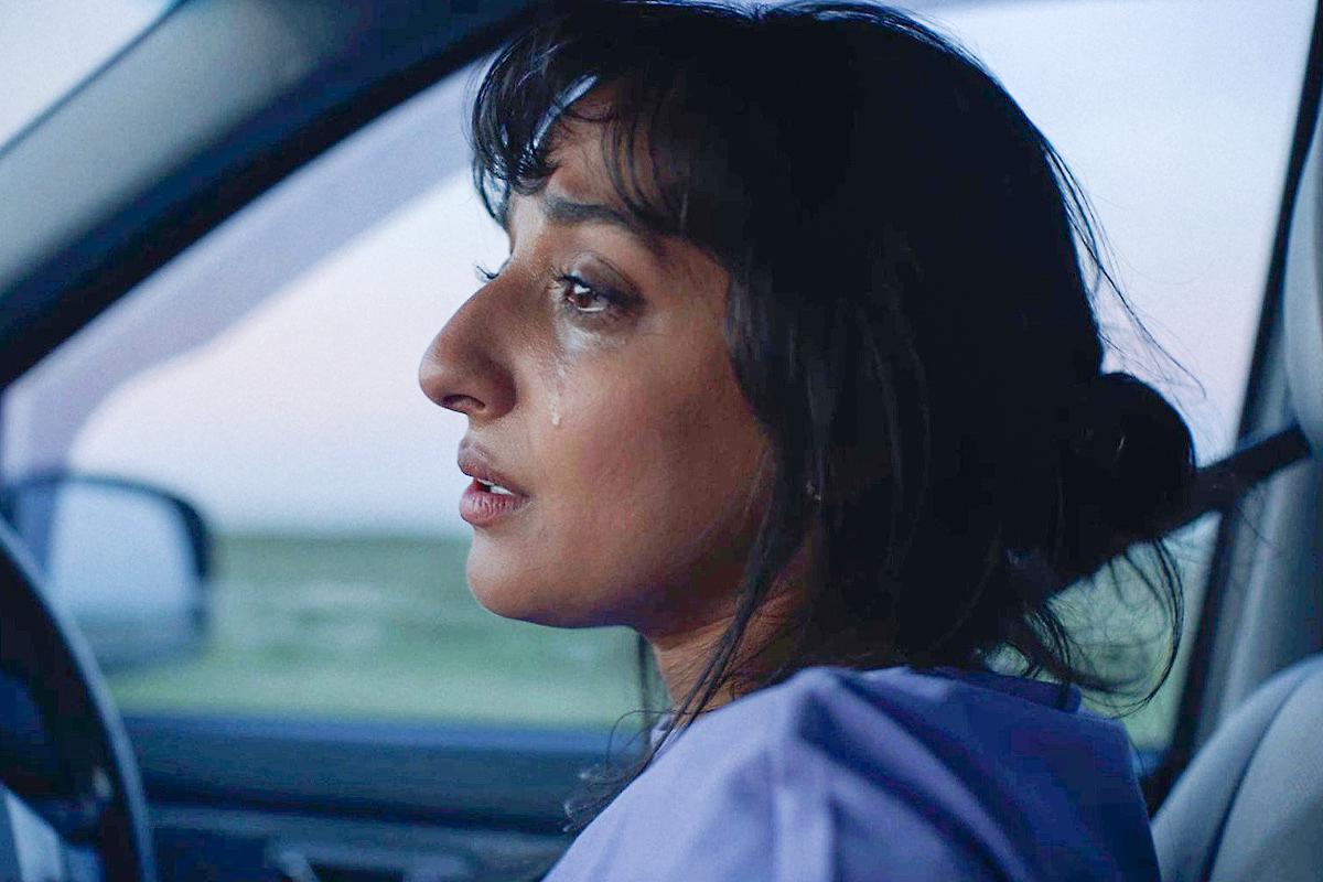 Ranjit sits in her car crying in a scene from F.O.G.